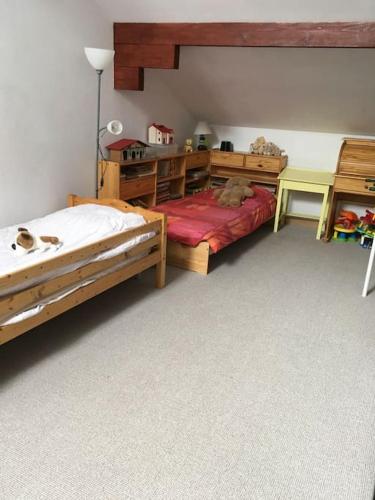 - une chambre avec 2 lits en bois et un bureau dans l'établissement Grande maison confortable à Bagnères, à Bagnères-de-Bigorre