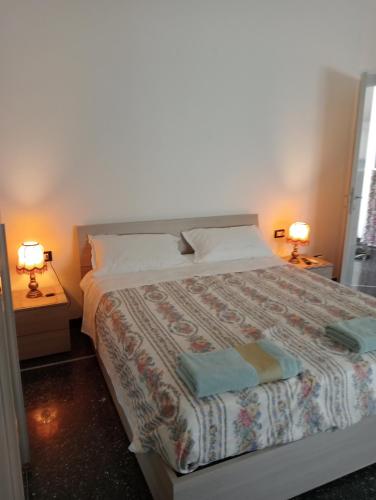 een slaapkamer met een bed met 2 lampen en 2 handdoeken bij elios home in Genua