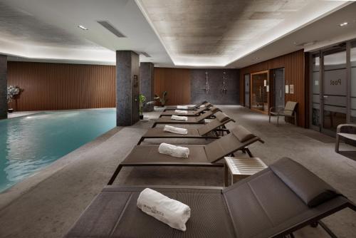 a row of chaise lounges next to a pool at Grands Suites Hotel Residences and Spa in Il-Gżira