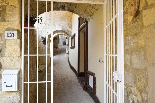 um corredor vazio de um edifício com um arco em Domum in petra casa nella roccia Self check - in em Modica