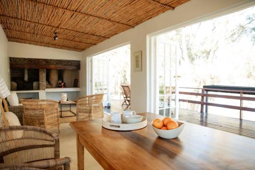 ein Wohnzimmer mit einem Holztisch mit Orangen darauf in der Unterkunft Melkhout River Cottage in Bonnievale