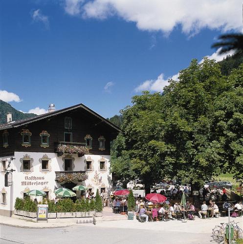 a group of people sitting outside of a building at Gasthaus Mitterjager in Kirchdorf in Tirol