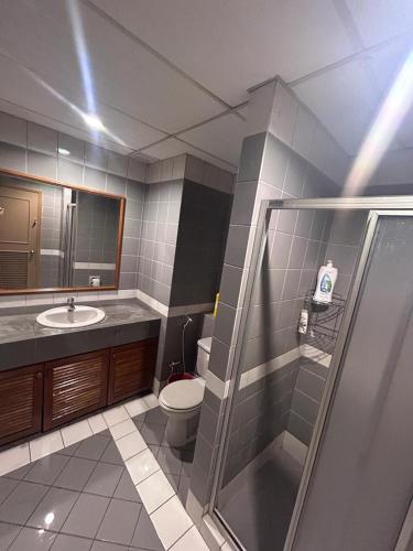 a bathroom with a toilet and a sink and a shower at Level 12 Riverbank suites 2BR RiverView in Kuching