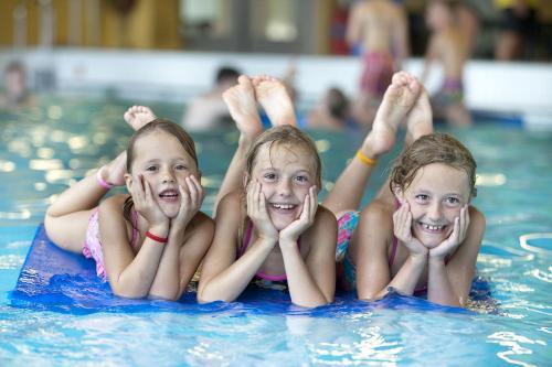 drie kinderen op een vlot in een zwembad bij Vakantiepark Klein Vink - 190 in Arcen
