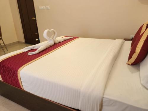 a white bed with a towel on top of it at Ebenezer Plaza in Nedumbassery