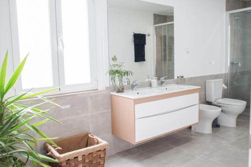 uma casa de banho com um lavatório e um WC em Aquarela do Tejo Guesthouse em Vila Franca de Xira