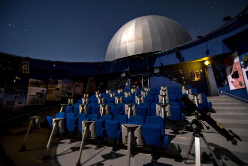 un observatoire astronomique avec des chaises bleues et un télescope dans l'établissement LE HAMEAU DES ETOILES, à Fleurance