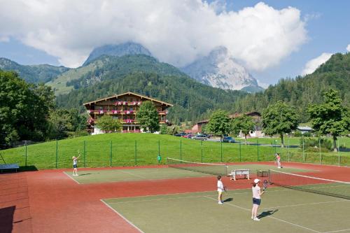 um grupo de pessoas a jogar ténis num campo de ténis em Gasthaus Mitterjager em Kirchdorf in Tirol