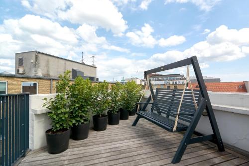 a bench sitting on a balcony with potted plants at LUXURY Penthouse · Private Balcony · Heart of Copenhagen in Copenhagen