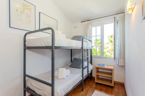 a bunk bed room with two bunk beds and a window at Aloes in Sa Caleta