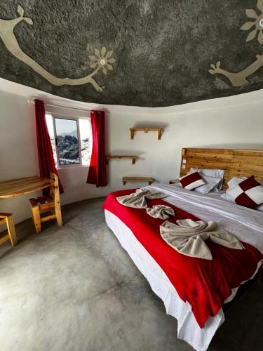 Portela的住宿－EcoFunco，一间卧室配有一张带红色床单的大床