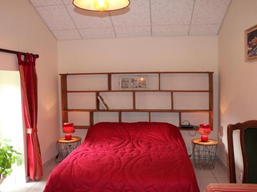 Un dormitorio con una cama con una colcha roja. en Charmant gîte rénové avec jardin, terrasse, cheminée et wifi - animaux acceptés - FR-1-489-22, en Châtel-de-Neuvre