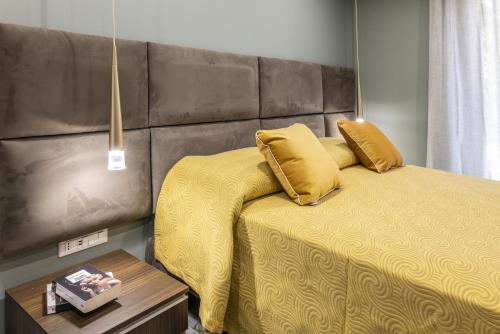a bedroom with a bed with yellow sheets and yellow pillows at Gold Luxury Flat x4 in Sorrento
