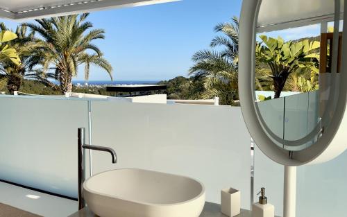 bagno con vasca bianca e specchio di Casa Tyane a Sant Jordi