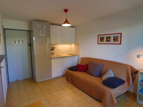 un salon avec un canapé et une cuisine dans l'établissement Studio cabine 25m² à Sète avec loggia, exposition est et parking sécurisé à proximité de la plage. - FR-1-472-122, à Sète