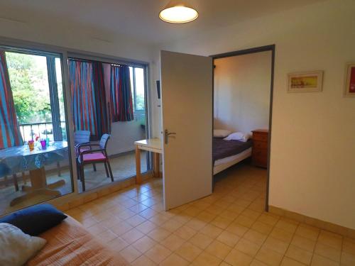 une chambre avec une porte s'ouvrant sur une chambre avec une table dans l'établissement Studio cabine 25m² à Sète avec loggia, exposition est et parking sécurisé à proximité de la plage. - FR-1-472-122, à Sète