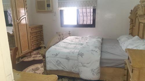 Madinah Anbariah في المدينة المنورة: غرفة نوم صغيرة بها سرير ونافذة