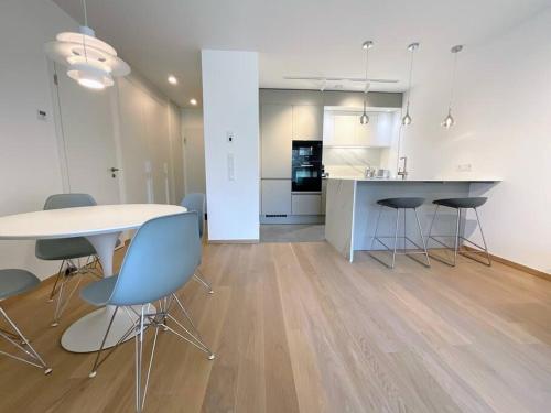 a kitchen and dining room with a table and chairs at Kirchberg Apartment - High End 1 bedroom Apartment with terrace & parking in Luxembourg