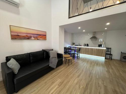 a living room with a black couch and a table at Carbonell 1 in Valencia