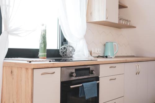 a kitchen with white cabinets and a black oven at Apartament nad Ustroniem in Gołdap