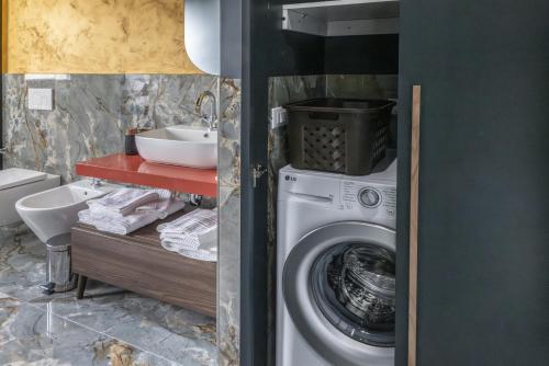 ein Badezimmer mit einer Waschmaschine und einem Waschbecken in der Unterkunft Gold Luxury Flat x4 in Sorrent