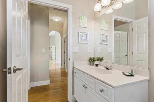 a white bathroom with a sink and a mirror at Evans Dr Endless Summer Pool Home Close To Golf Course Palm Coast Pet Friendly in Palm Coast