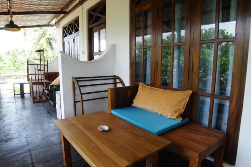 a room with a bench and a table and windows at Turtle Bay Beach Resort in Mirissa