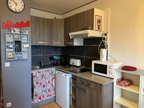 une petite cuisine avec un réfrigérateur et un micro-ondes dans l'établissement Agréable Studio 3 Places à P2000 Résidence Les Myrtilles, à Bolquère-Pyrénées 2000