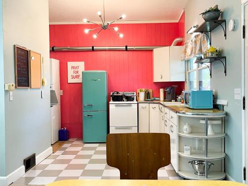 a kitchen with a green refrigerator and red walls at NEW! Mid-Century Modern Themed Family Home! in Vermilion