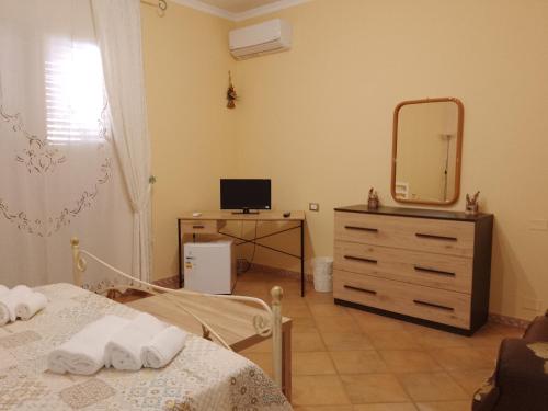 a bedroom with a bed and a mirror and a dresser at Casamia in Portopalo