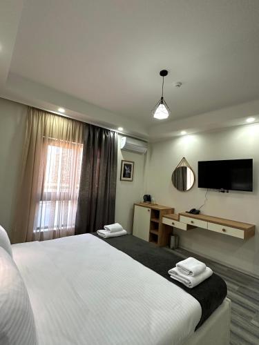 a bedroom with a bed and a desk and a television at Luxmani Hotel & Spa in Tbilisi City