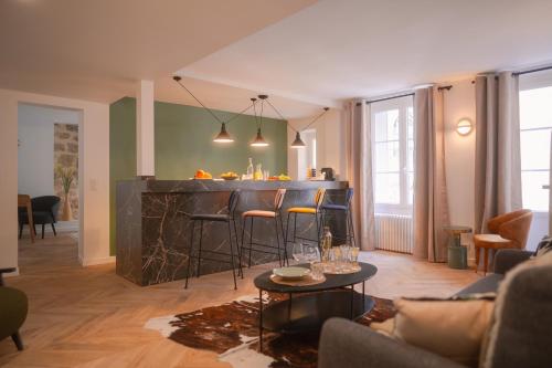 una sala de estar con un bar con taburetes en Le M. Musée du vin - l'appartement, en París