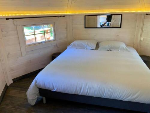 ein Schlafzimmer mit einem großen weißen Bett in einem Zimmer in der Unterkunft La Cabane perchée de la Mure in Bongheat