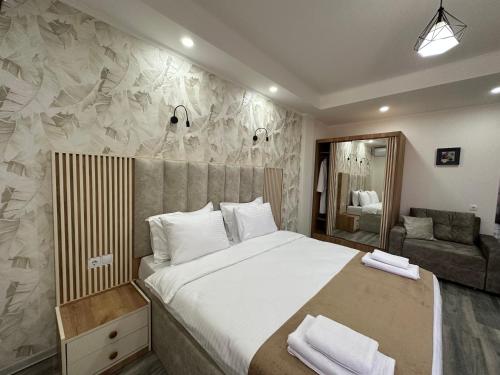 a bedroom with a large bed and a couch at Luxmani Hotel & Spa in Tbilisi City
