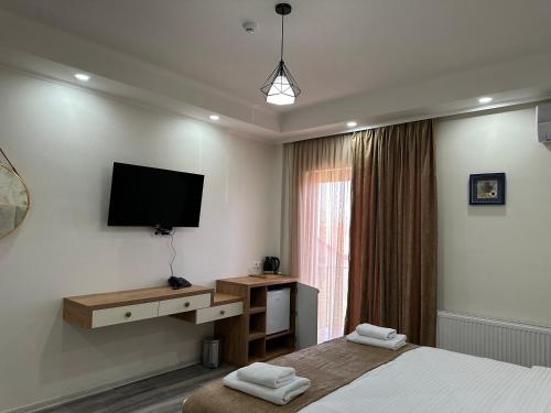 a bedroom with two beds and a television on the wall at Luxmani Hotel & Spa in Tbilisi City