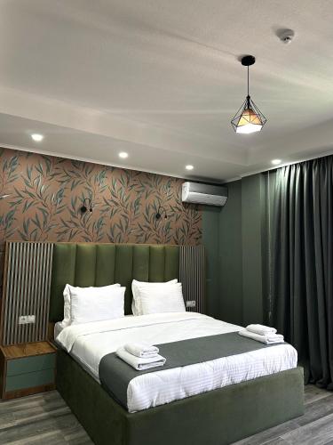a bedroom with a large bed with a green headboard at Luxmani Hotel & Spa in Tbilisi City