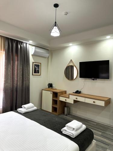 a hotel room with two beds and a flat screen tv at Luxmani Hotel & Spa in Tbilisi City