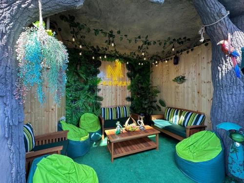 a living room with chairs and a table and a tree at Luxmani Hotel & Spa in Tbilisi City
