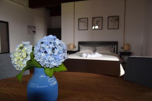 a blue vase with blue flowers on a table in a bedroom at Monasterio y Pensión de Moraime in Muxia