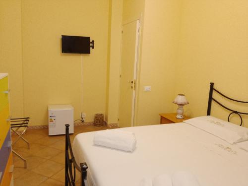a bedroom with a bed and a tv on the wall at Casamia in Portopalo