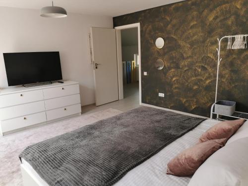 a bedroom with a bed and a tv on a wall at Casa Good Vibes in Târgu-Mureş