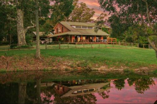 a house with a reflection in the water at Topview Farm in Dunns Creek