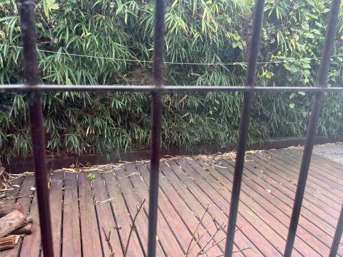 Elle offre une vue sur une terrasse en bois traversant une clôture. dans l'établissement OM, à Canelones