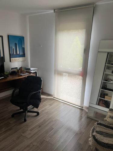 una oficina con silla, escritorio y ventana en OM, en Canelones