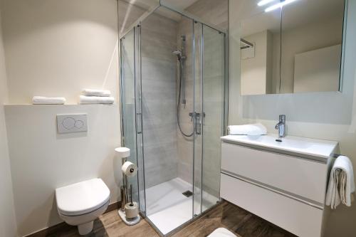 a bathroom with a shower and a toilet and a sink at Casa Grande in Techelsberg am Worthersee