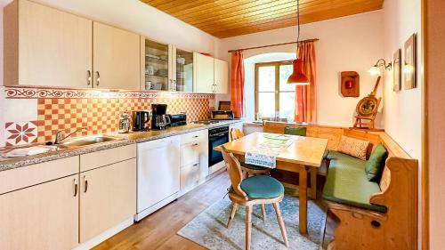 a kitchen with a wooden table and a table and chairs at Almbauernhof in Ruhpolding