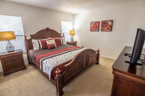 Dormitorio con cama, escritorio y TV en Nicks Southern Dunes Vacation Home, en Haines City