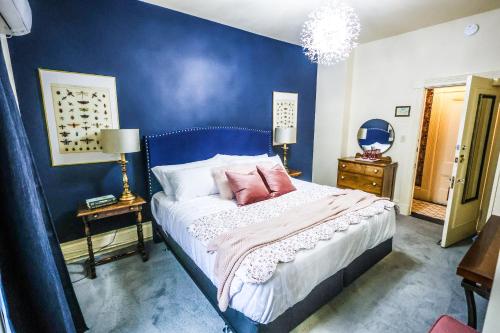 1 dormitorio azul con 1 cama con 2 almohadas rosas en The Lunenburg Inn, en Lunenburg