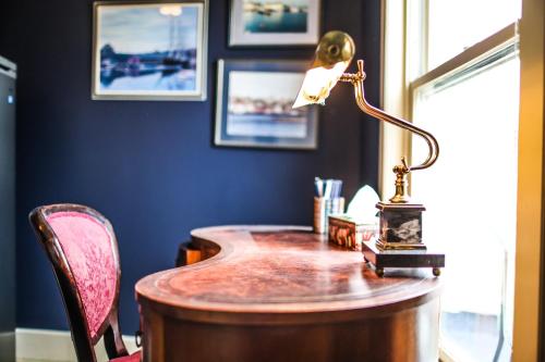una oficina con un escritorio con una lámpara. en The Lunenburg Inn en Lunenburg