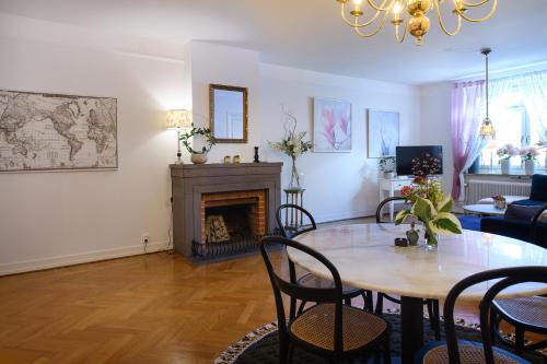 a living room with a table and a fireplace at HoMade B&B, Gamla Stan in Norrköping